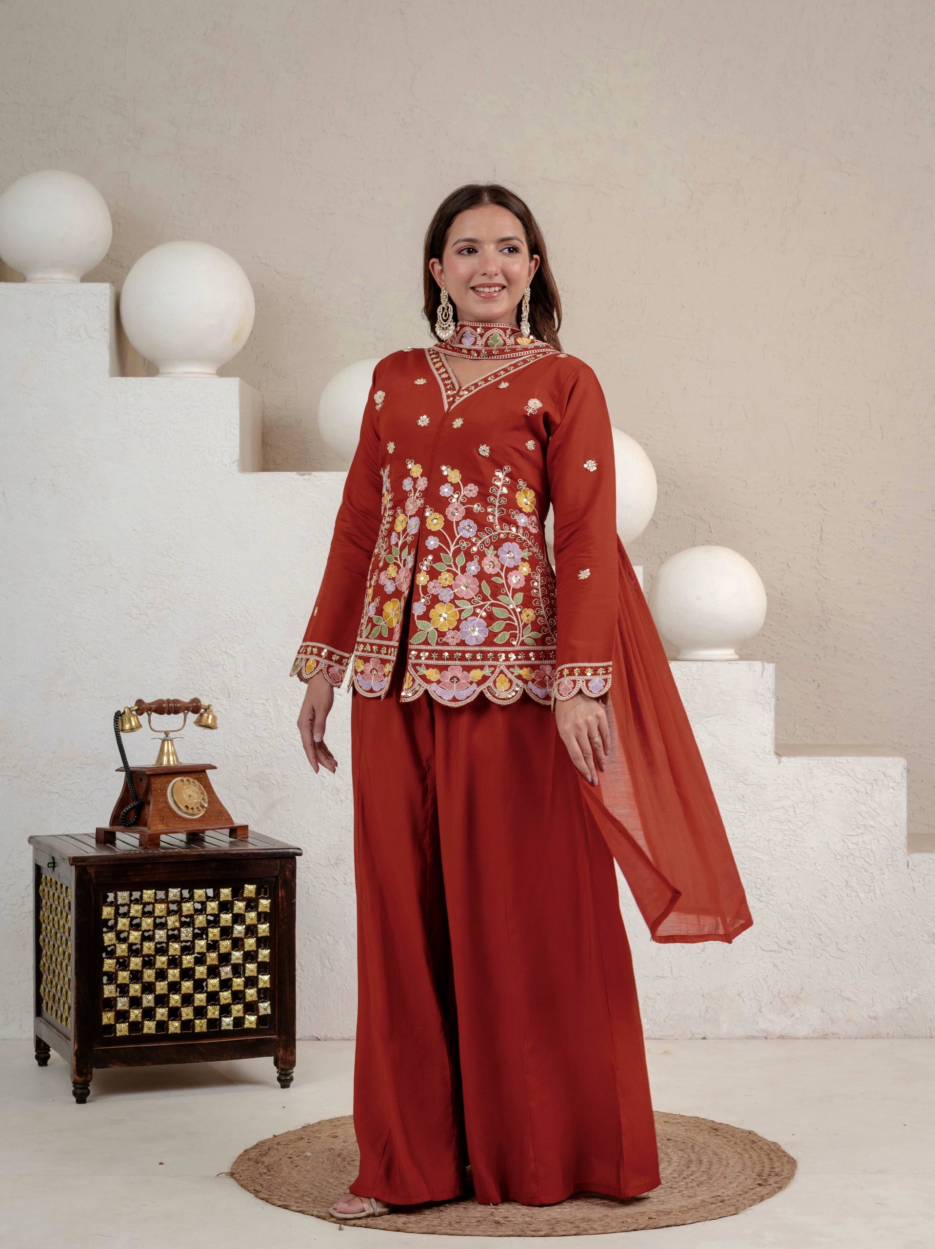 Resplendent Rust Orange Peplum Kurti and Flared Palazzo Suit Set Adorned with Intricate Multicolored Floral Embroidery, Sequin Accents, and Ornate Scalloped Borders